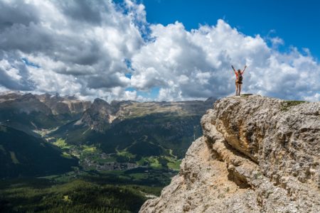 Woman standing on cliff overlooking mountain range