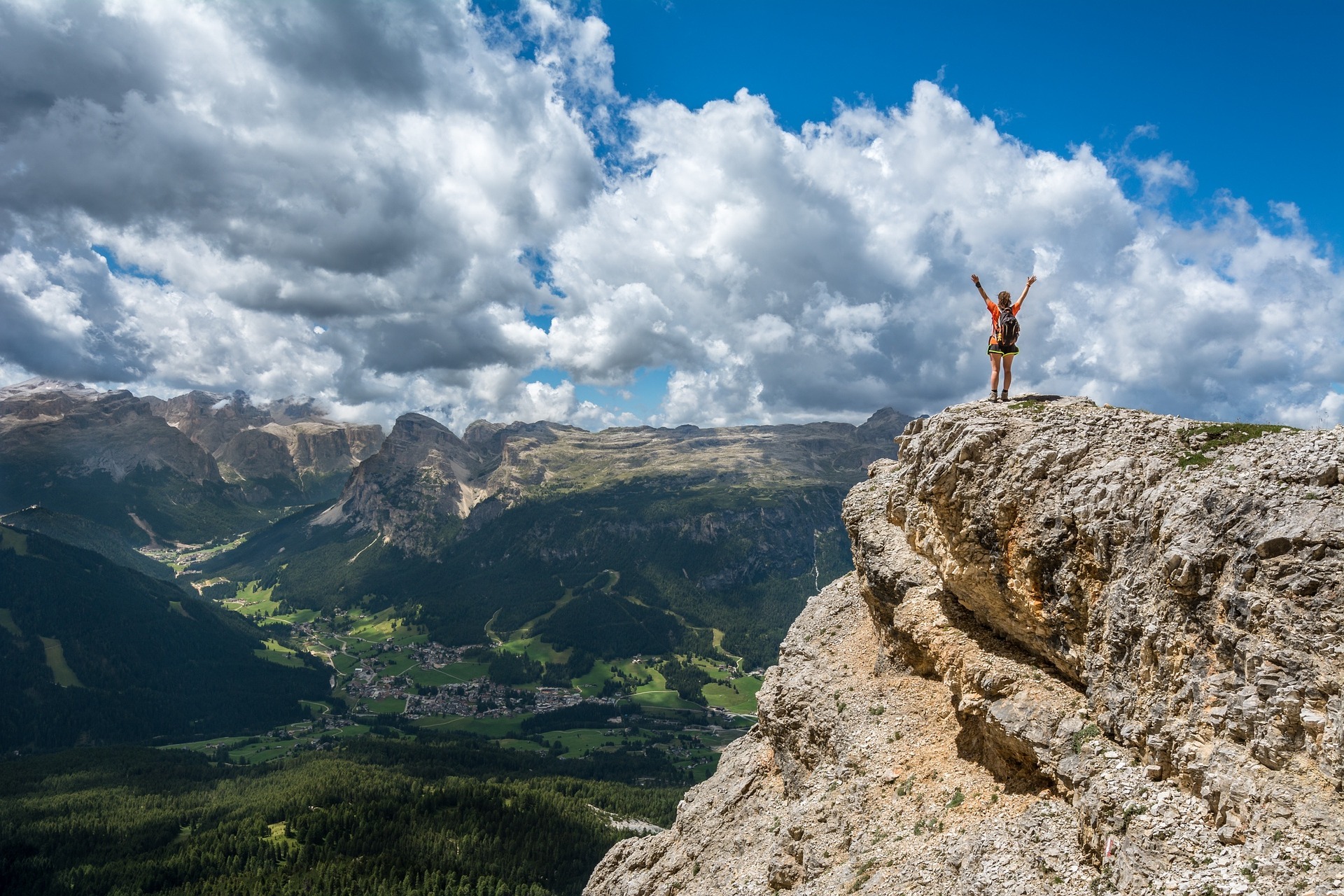 Woman standing on cliff overlooking mountain range