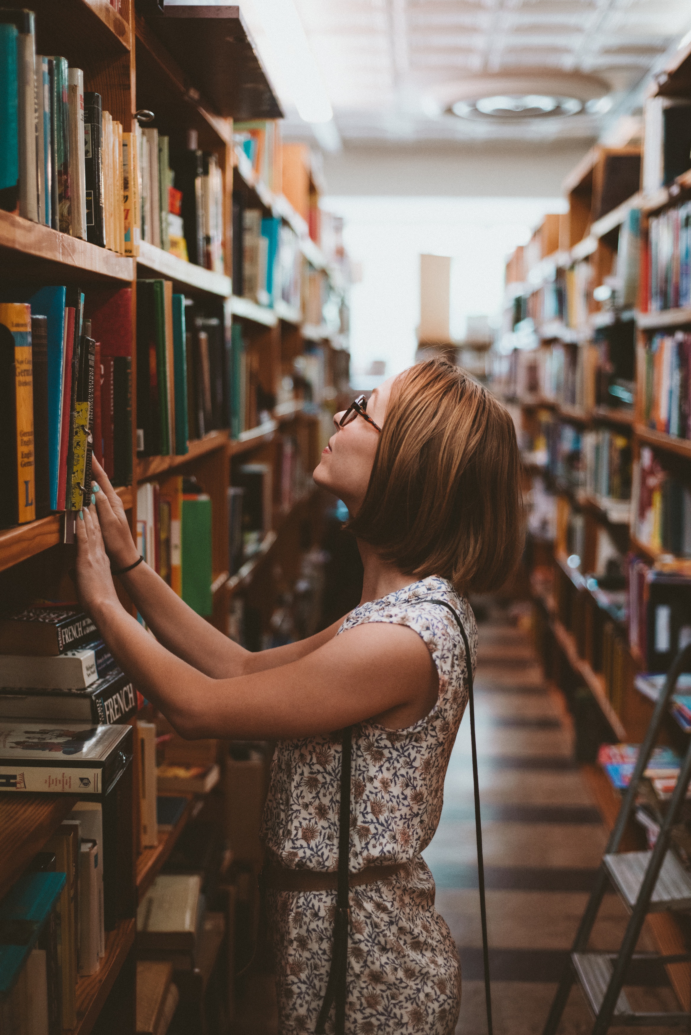 Woman looking at library bookshelf